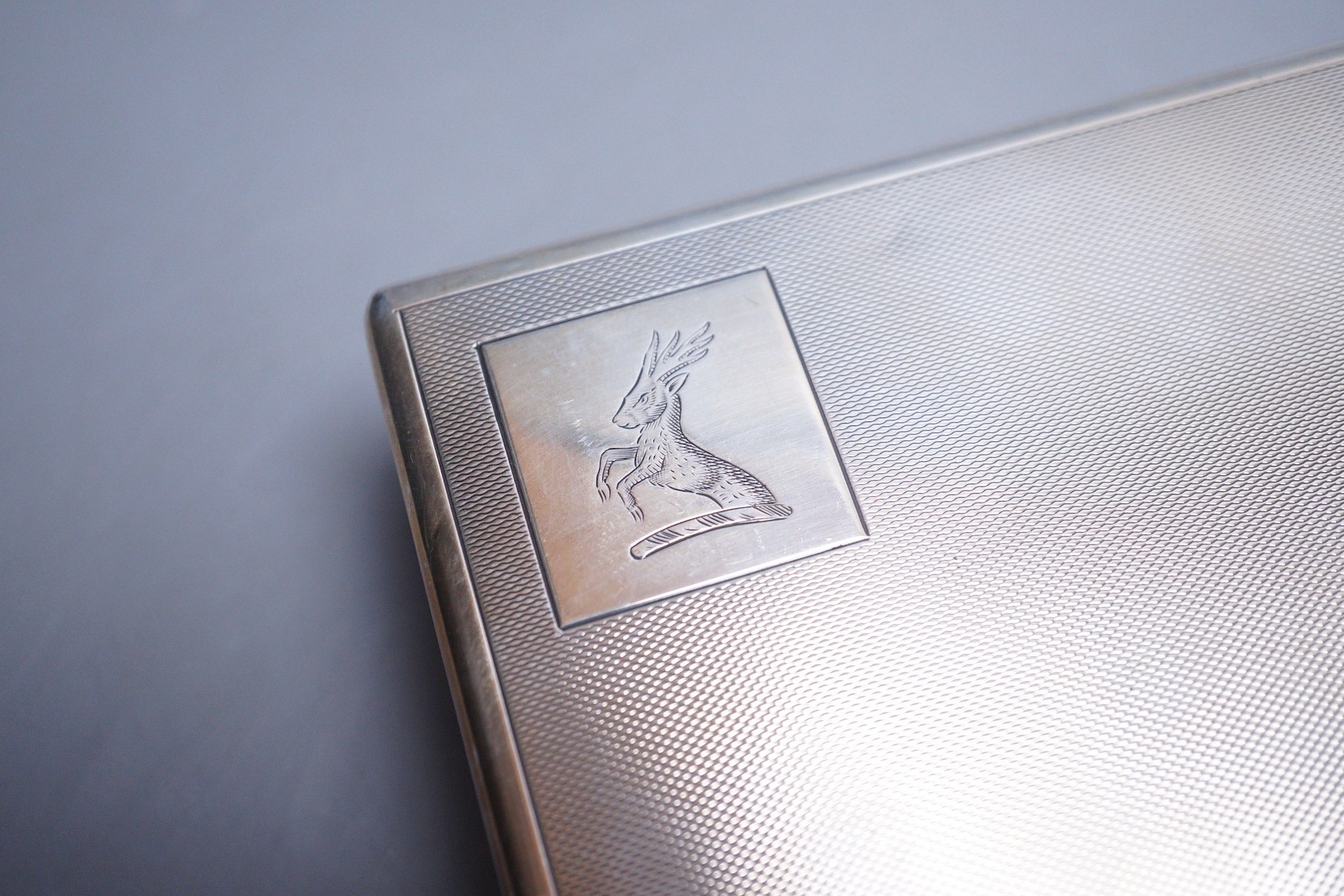 A late 1950's engine turned silver mounted rectangular cigarette box, by Mappin & Webb, 14cm and one other smaller silver mounted cigarette box.